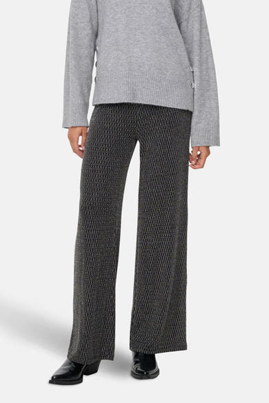 Zwarte broek met geometrische patronen van ONLY, gedragen met een grijze trui en zwarte schoenen.