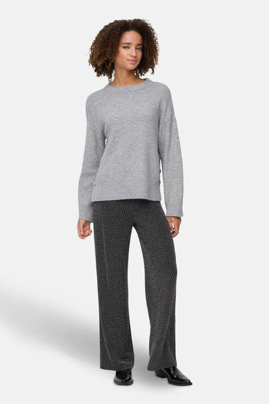 Pantalon noir à motifs géométriques de ONLY, porté avec un pull gris et des chaussures noires.
