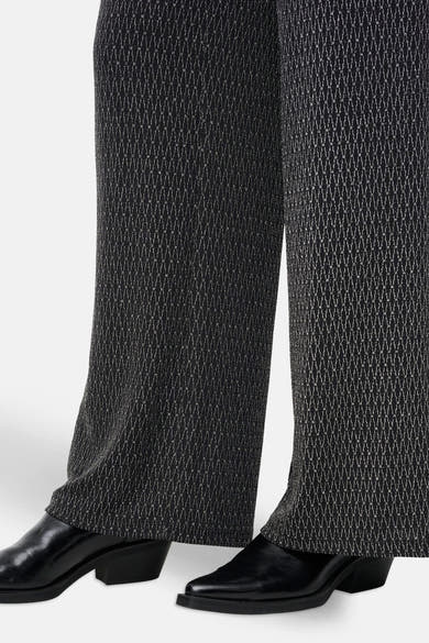 Zwarte broek met kettingpatroon, van ONLY®, gedragen met zwarte lakleren schoenen.