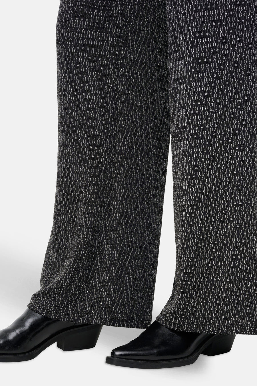 Zwarte broek met kettingpatroon, van ONLY®, gedragen met zwarte lakleren schoenen.