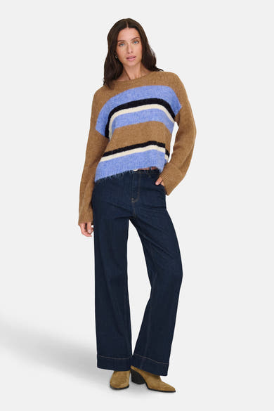 Pull à rayures multicolores de ONLY, porté avec un jean évasé et des bottines en daim.

