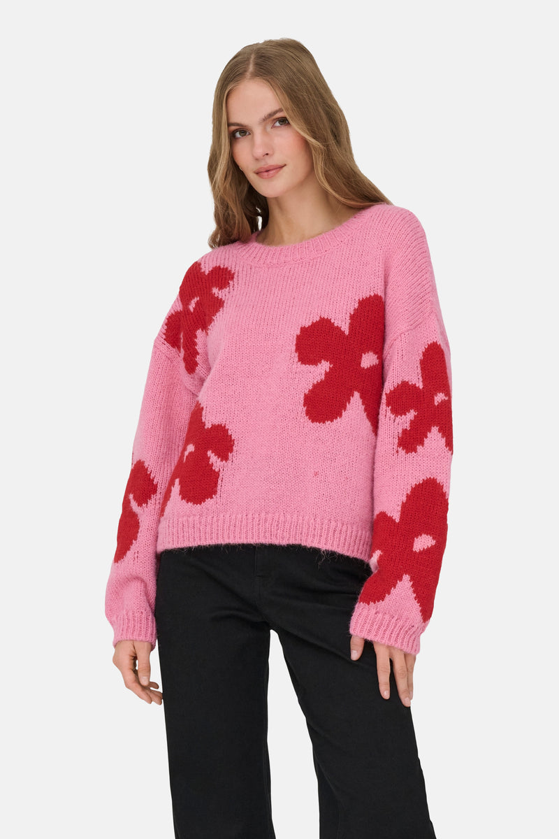 Roze top met rode bloemen van ONLY, gedragen met een zwarte broek.