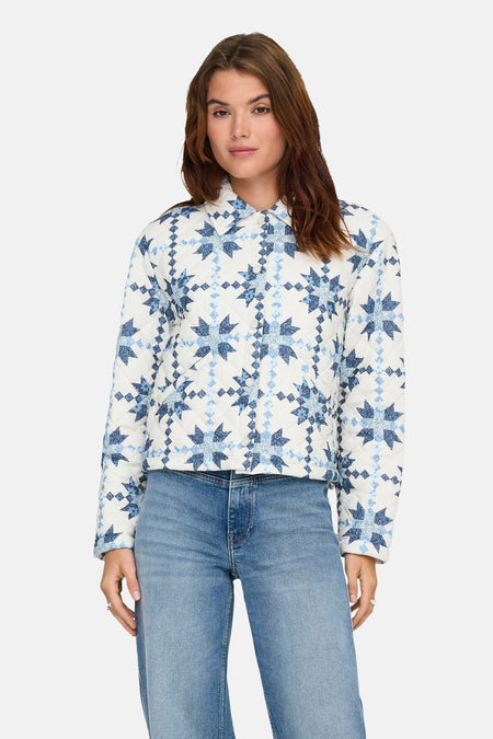 Veste courte multicolore de ONLY, avec un motif patchwork étoilé et un matelassage. Portée avec un jean bleu.