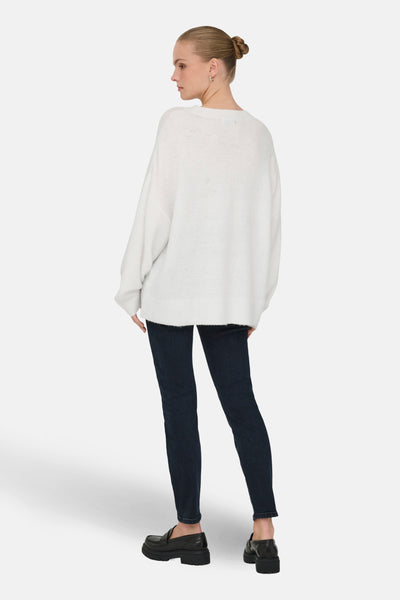 Pull à col rond blanc de JDY, porté avec un jean bleu foncé et des chaussures épaisses noires.