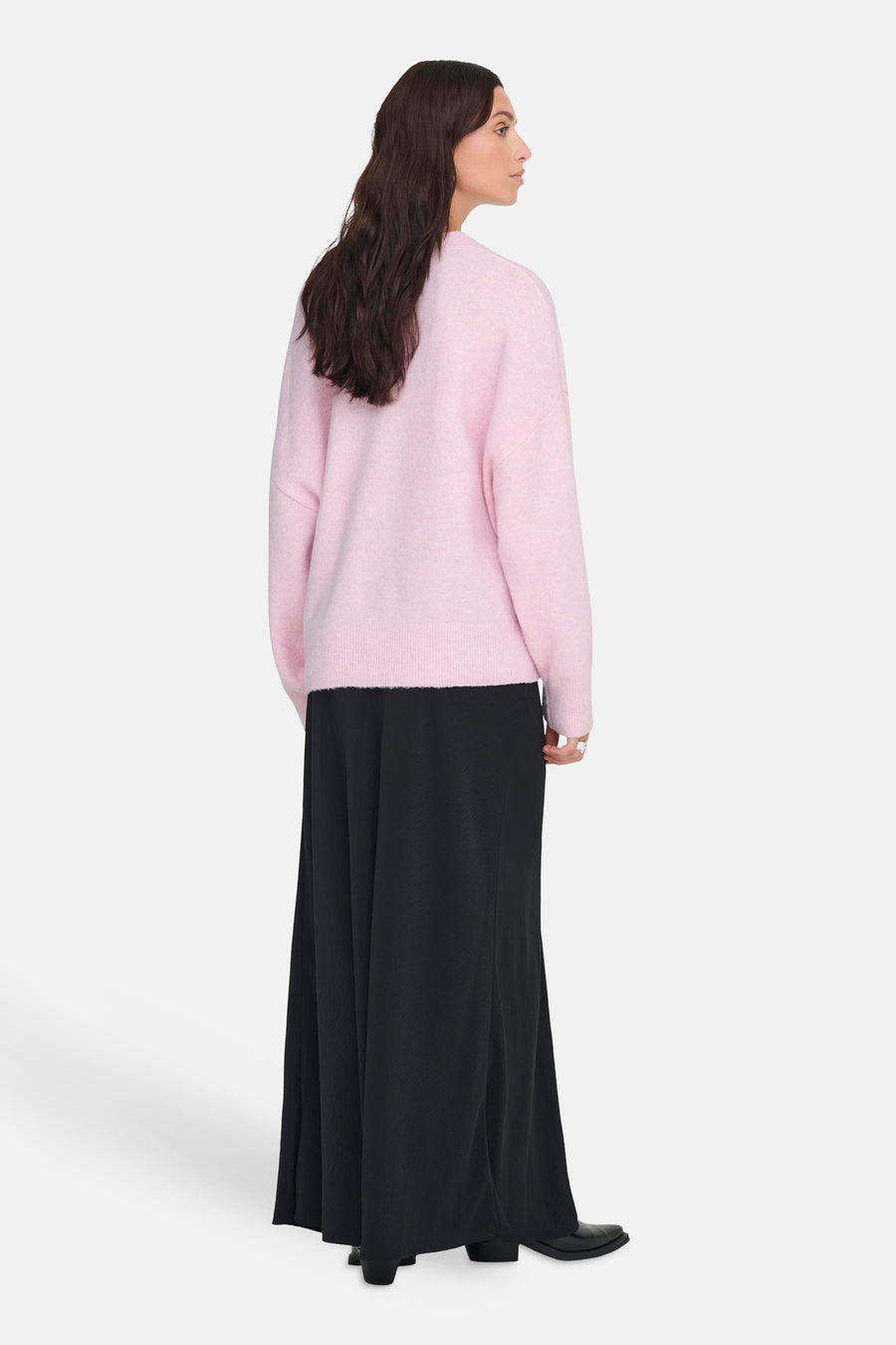Pull rose à col rond de JDY porté avec une longue jupe noire fluide.
