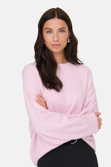 Pull rose à col rond de JDY, porté avec un pantalon noir et des boucles d'oreilles argentées.