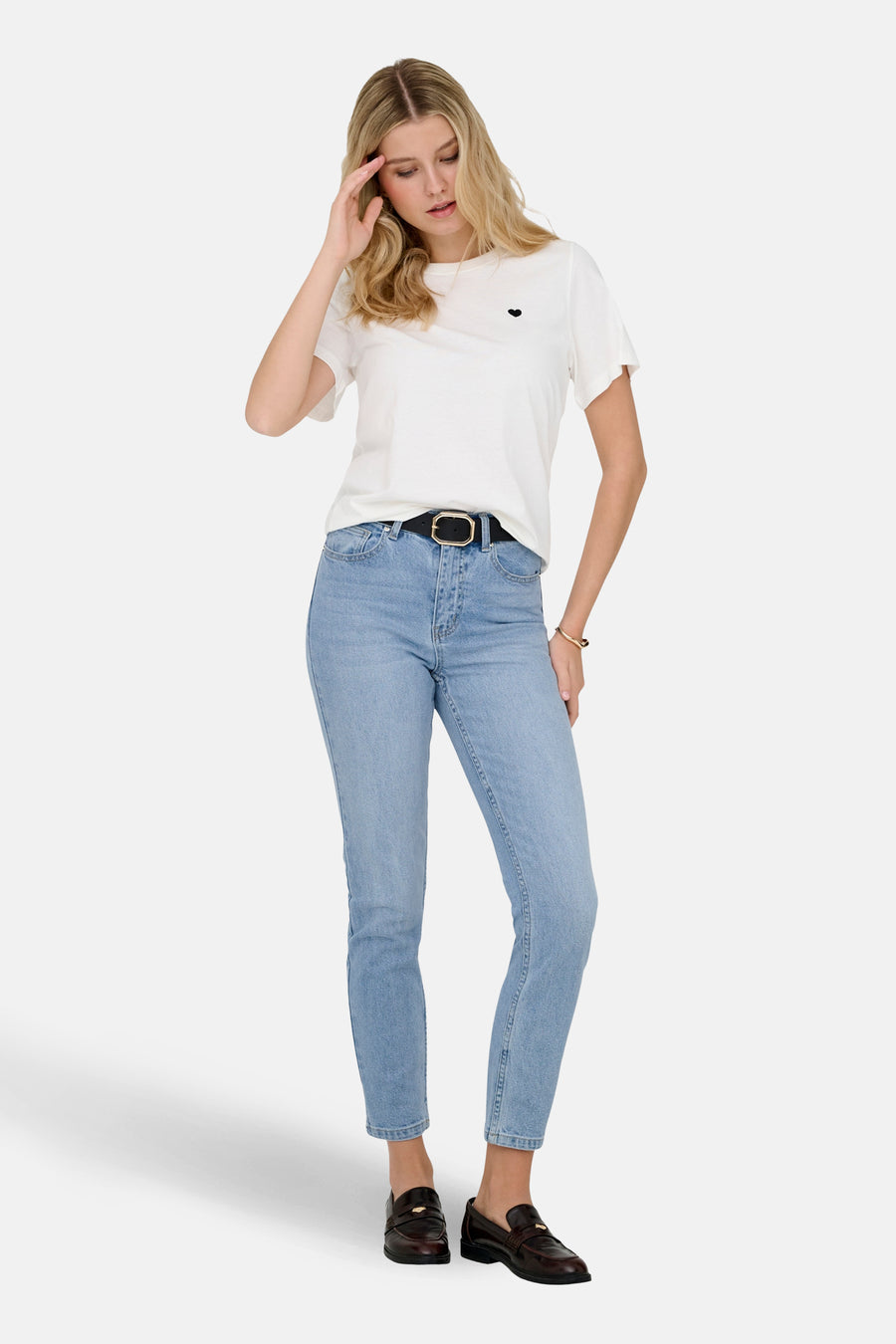 Jean mom bleu clair de ONLY®, porté avec une ceinture noire et des mocassins marron.
