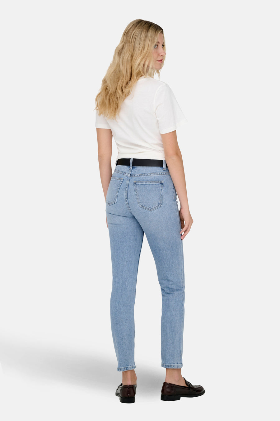 Lichtblauwe Mom jeans van ONLY, gedragen met een zwarte riem en bruine leren loafers.