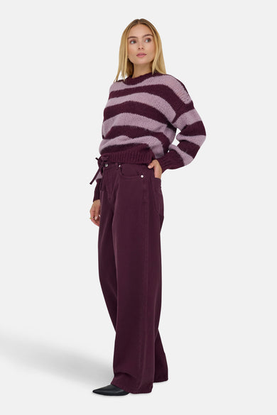 Gekleurde bordeauxrode jeans van ONLY®, losse pasvorm en wijde pijpen, gedragen met een gestreepte roze en bordeauxrode trui.