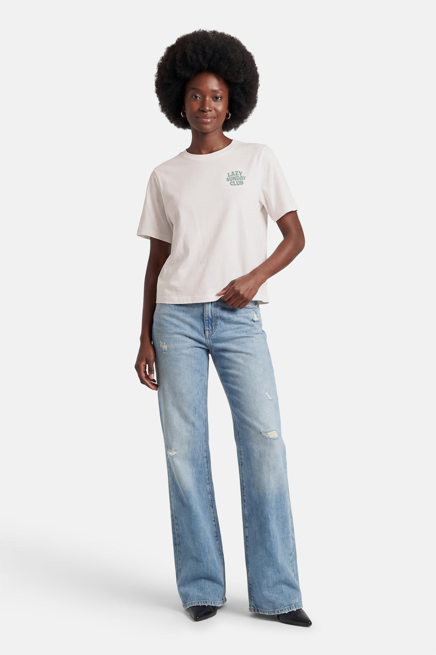 Wit T-shirt met korte mouwen van ONLY®, met de tekst "Lazy Sunday Club" en gedragen met een wijde jeans.