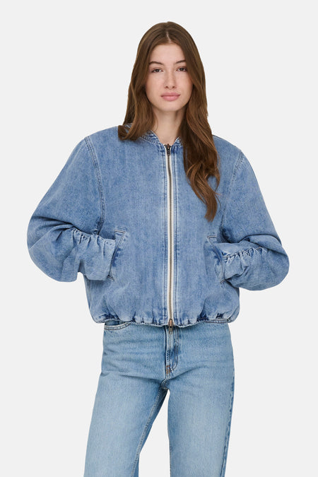 Veste denim bleu moyen de ONLY, portée avec un jean assorti, avec fermeture éclair et poches.