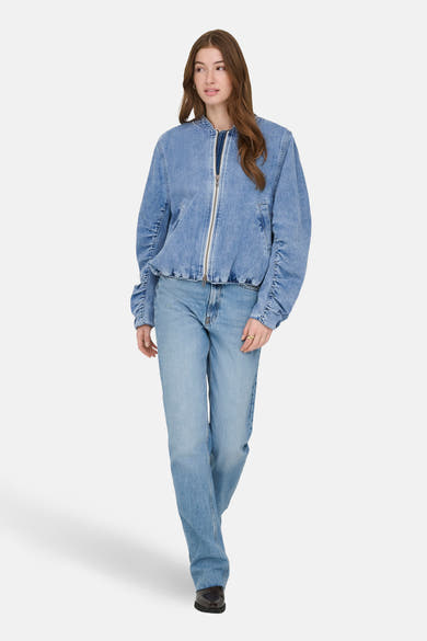 Veste denim bleu moyen de ONLY®, avec fermeture éclair et manches froncées, portée avec un jean assorti.
