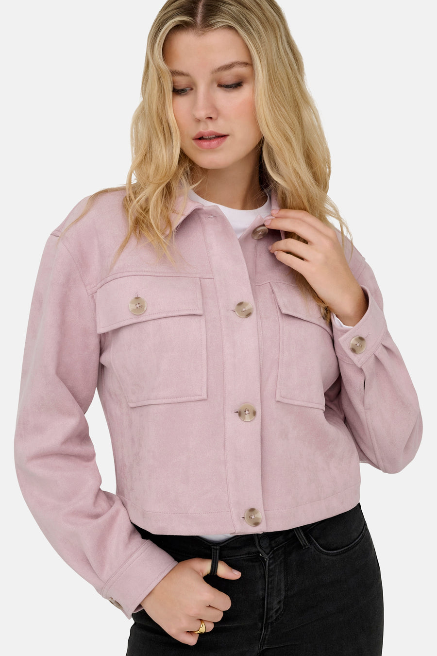 Kort roze jasje van ONLY, met ton-sur-ton knopen en klepzakken, gedragen over een wit T-shirt en een zwarte jeans.