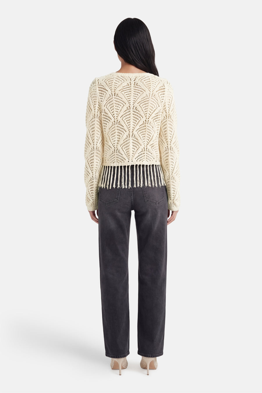 Pull beige de ONLY® en maille ajourée avec franges, vue de dos, porté avec un jean gris et des talons.