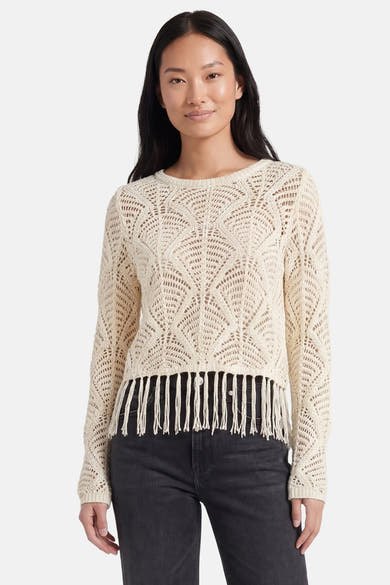 Beige trui van ONLY® in opengebreide stof met franjes, van achteren gezien, gedragen met een grijze jeans en hakken.