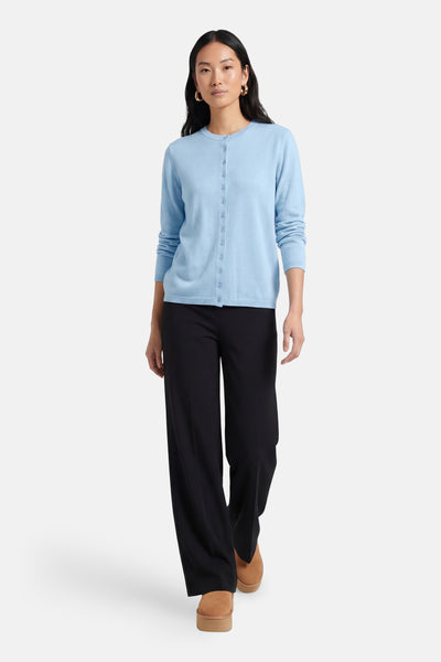 Cardigan bleu clair par JDY, porté avec un pantalon noir et des chaussures marron à plateforme.