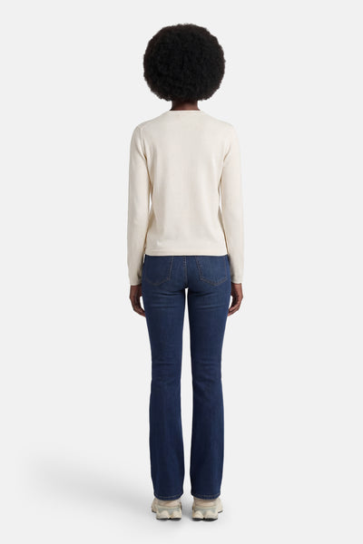 Cardigan beige de JDY, vue de dos, porté avec un jean bleu et des baskets beiges.
