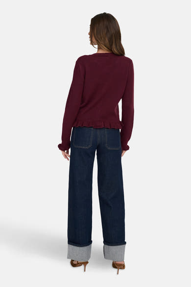 Bordeaux vest van JDY met rucheszoom, gedragen met een wijde jeans met omslag en hoge hakken.