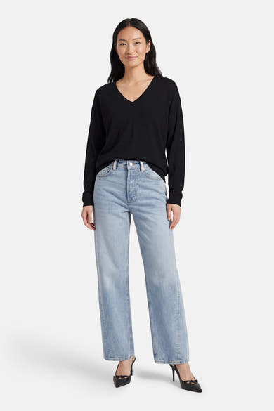 Zwarte V-hals trui van JDY, gedragen met een high-waisted jeans en zwarte pumps met hak.