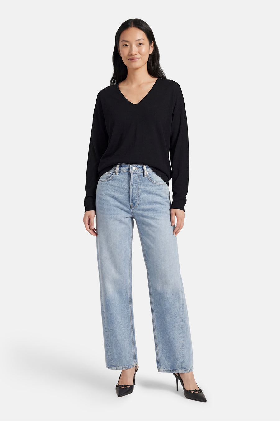 Zwarte V-hals trui van JDY, gedragen met een high-waisted jeans en zwarte pumps met hak.