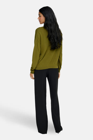 Groene V-hals trui van JDY, gedragen met een zwarte wijde broek, achtergezicht.