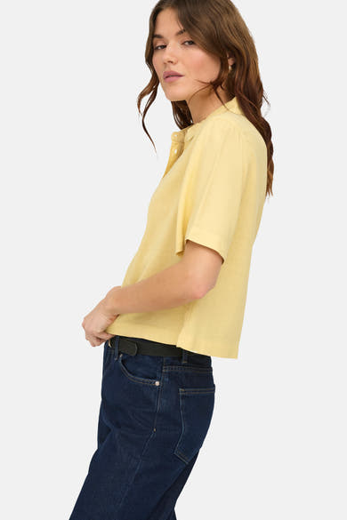 Chemisier jaune à manches courtes de ONLY, porté avec un jean taille haute et une ceinture noire.