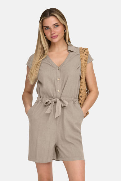 Beige combishort, van ONLY®, met elastische tailleband, gedragen met een bruine nettas en platte schoenen.