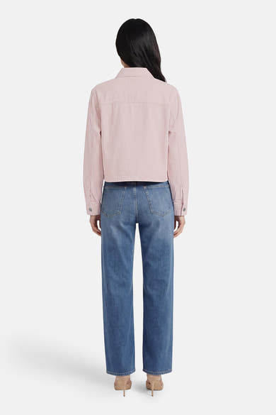 Veste en jean rose de ONLY®, coupe courte, vue de dos, portée avec un jean bleu et des talons nude.