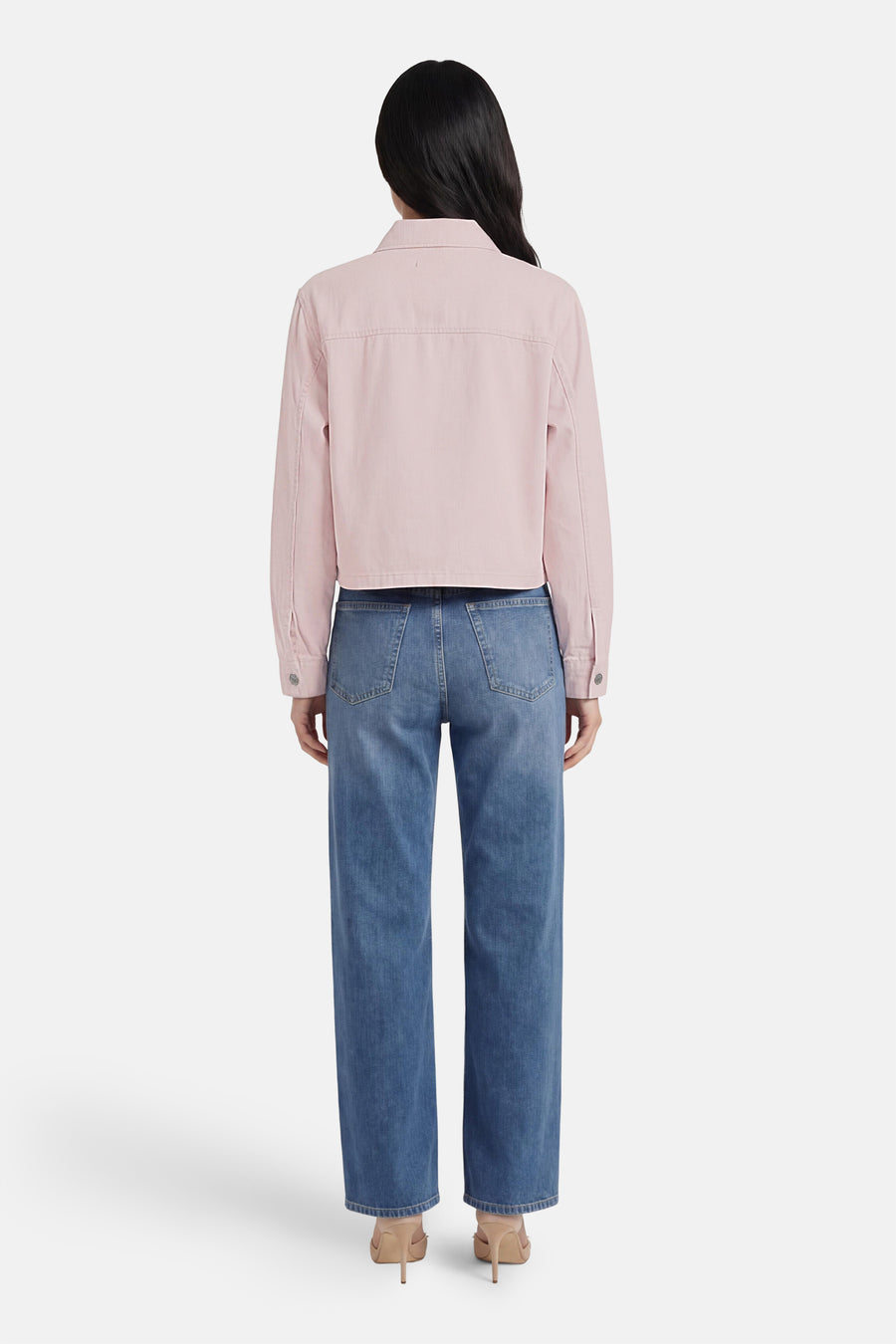 Veste en jean rose de ONLY®, coupe courte, vue de dos, portée avec un jean bleu et des talons nude.