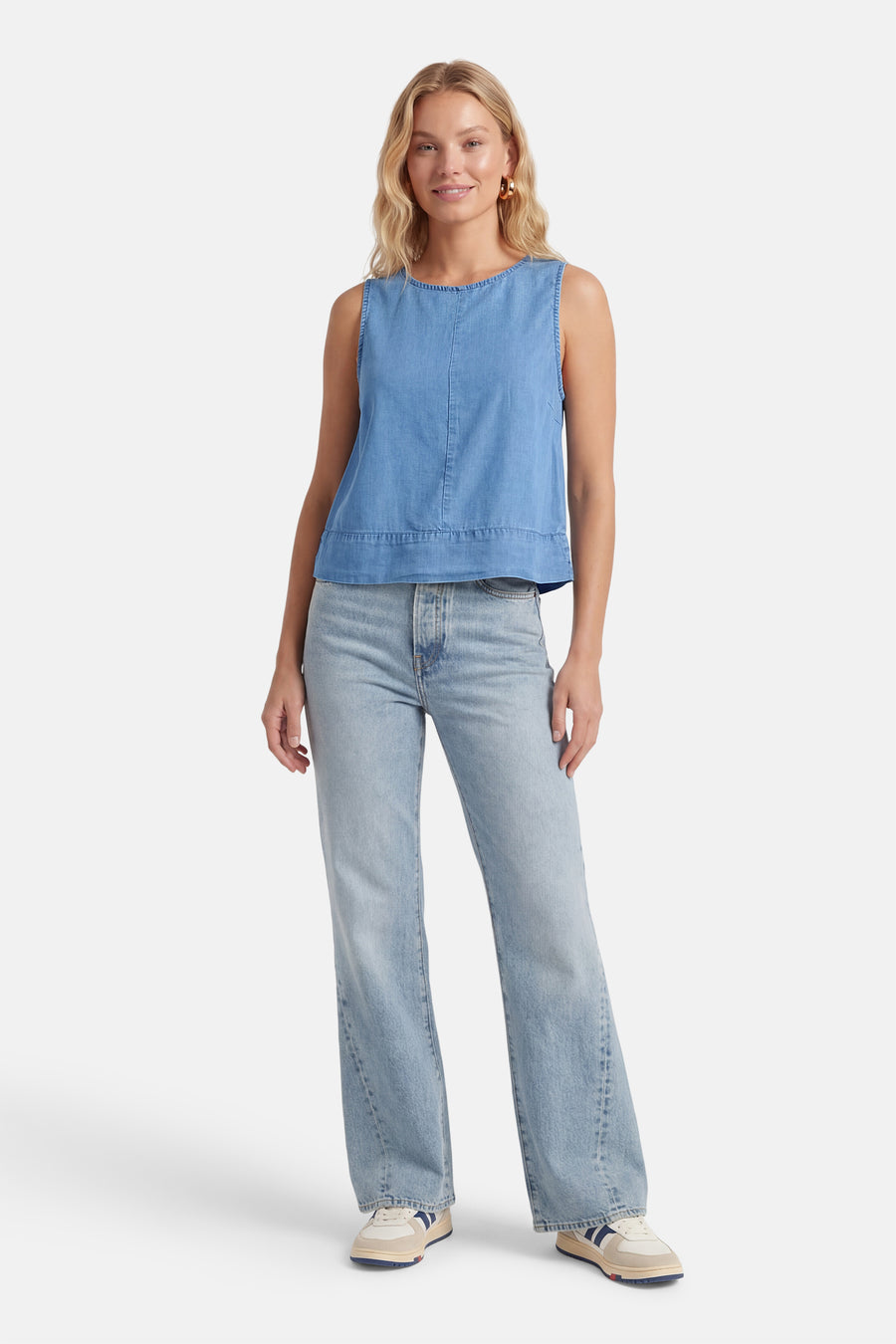 Mouwloos top van middinblauw denim van ONLY®, gedragen met een spijkerbroek en tweekleurige sneakers.