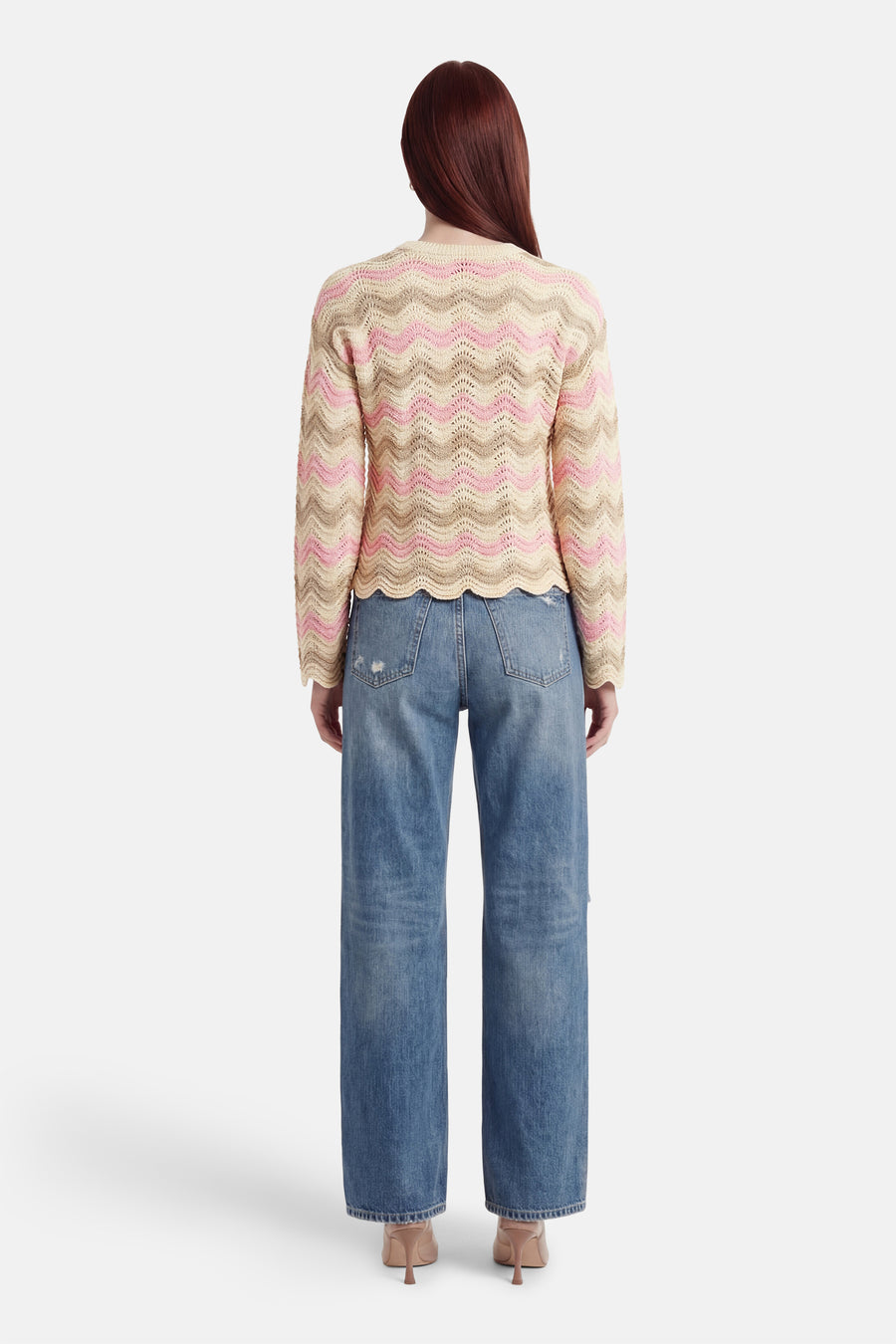 Multikleuren rondehals trui van ONLY®, met een golvend patroon in roze, beige en bruin, gedragen met een wijde blauwe jeans.