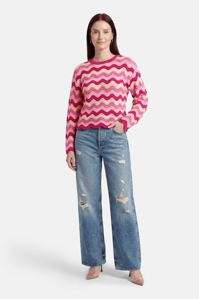 Pull à col rond rose ONLY®, à rayures ondulées roses et beiges, porté avec un jean bleu délavé