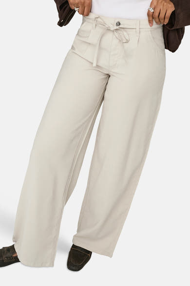 Jeans écru ample de la marque ONLY avec cordon à nouer à la taille, porté avec une veste marron et des mocassins foncés.