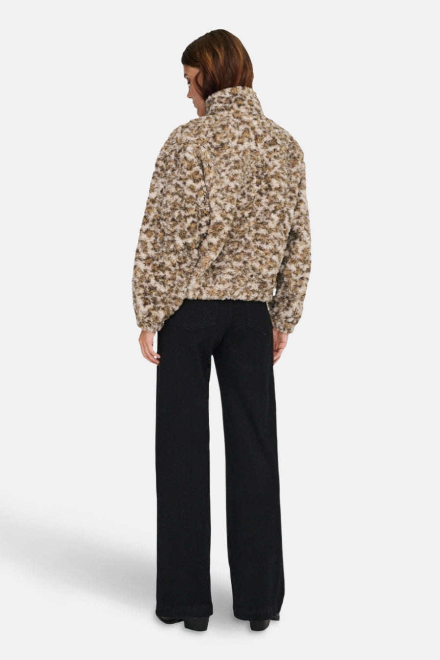 Korte beige jas van ONLY, met een bouclé textuur en gedragen met een zwarte wijde broek.