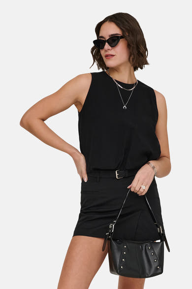Top sans manches noir de la marque ONLY®, porté par une femme avec des lunettes de soleil et un sac à main clouté.