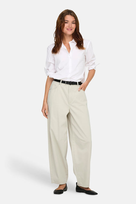 Pantalon écru ONLY®, porté avec une ceinture noire et une chemise blanche.