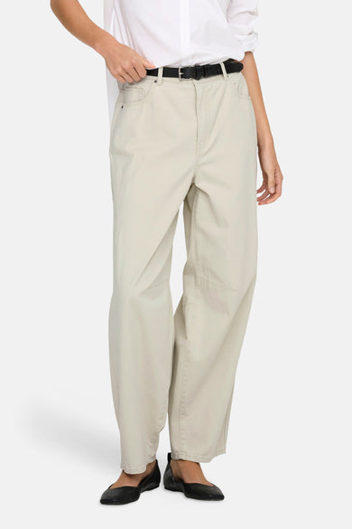 Pantalon écru par ONLY®, ample, porté avec une ceinture noire et des ballerines noires.
