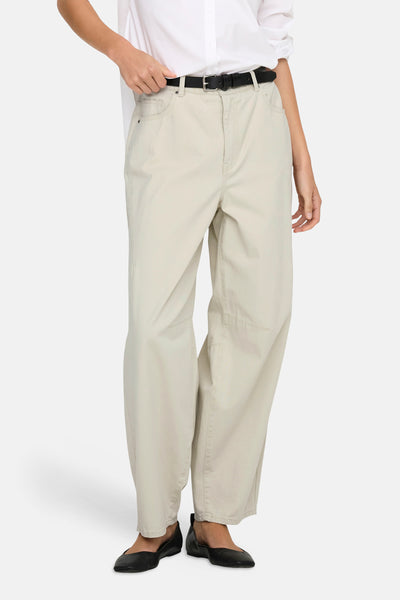 Pantalon écru par ONLY®, ample, porté avec une ceinture noire et des ballerines noires.