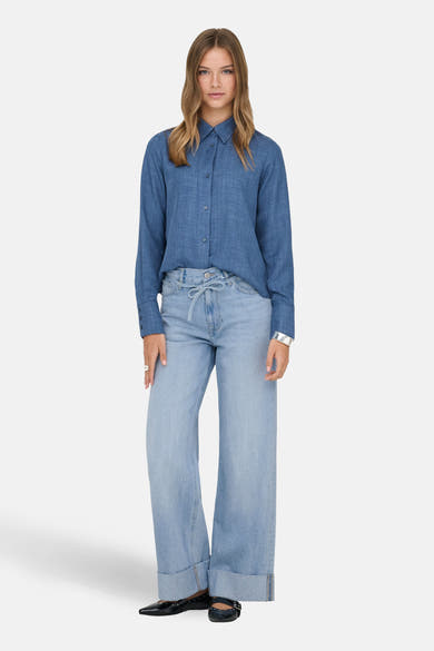 Jean large en denim bleu clair de ONLY, porté avec une chemise et des ballerines noires.
