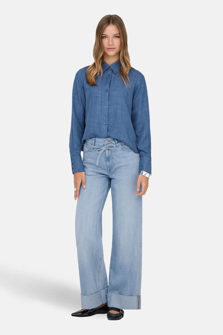 Jean large en denim bleu clair de ONLY, porté avec une chemise et des ballerines noires.
