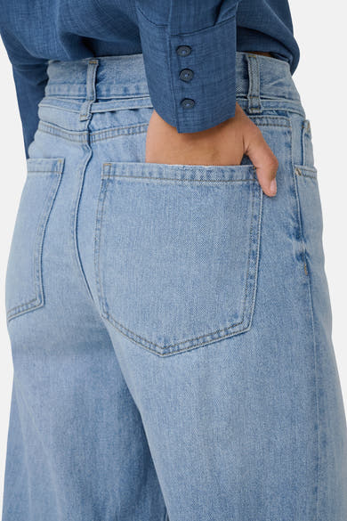 Jean large en denim bleu clair de ONLY, avec une main dans la poche arrière.
