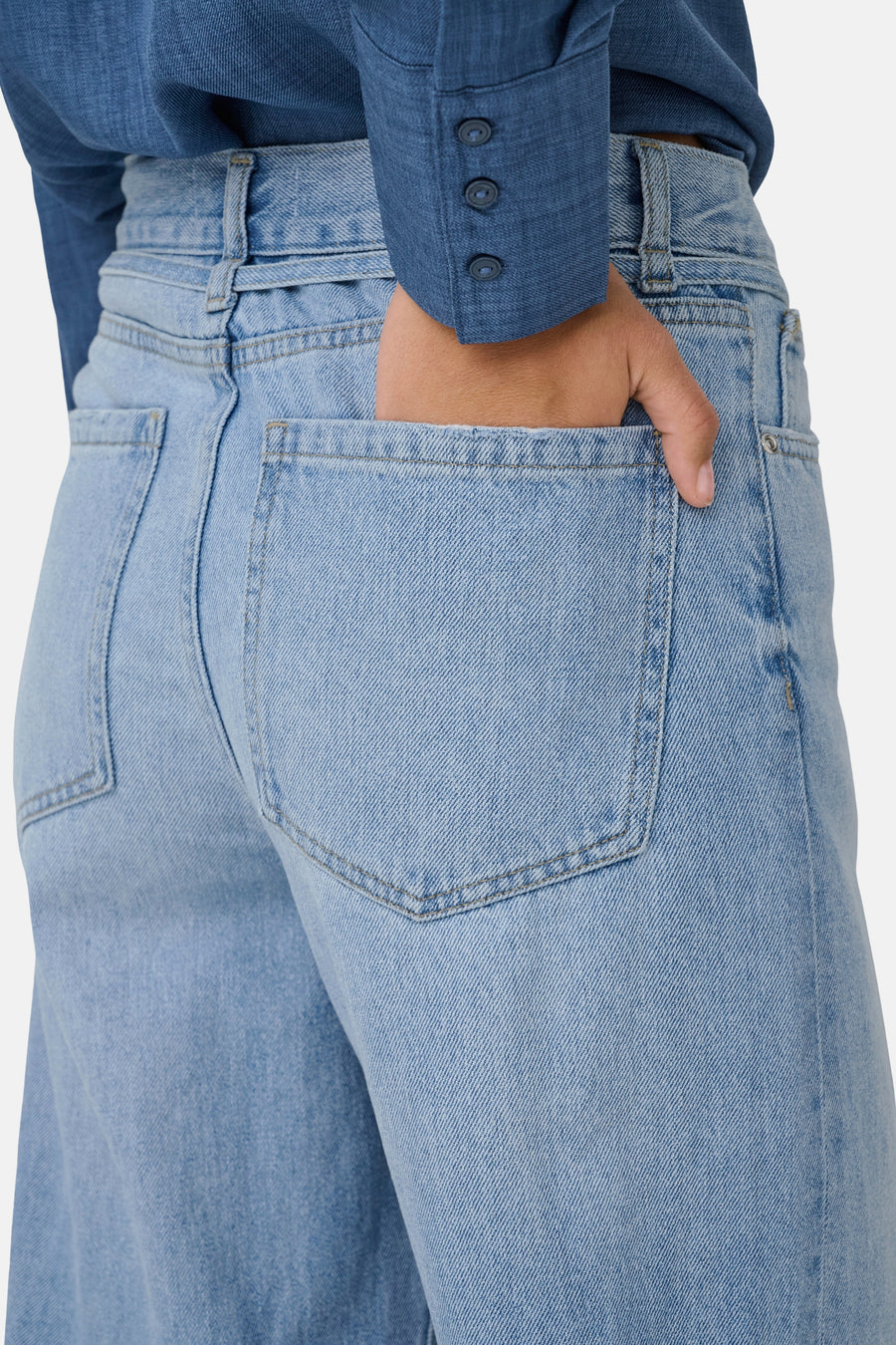 Jean large en denim bleu clair de ONLY, avec une main dans la poche arrière.
