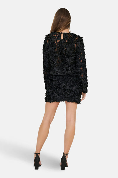 Zwarte blouse met lange mouwen van ONLY®, getextureerd met bloemenpatronen op een doorschijnende achtergrond, achterzijde.