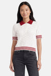 Pull multicolore de ONLY® avec motif ajouré, col et rayures rouges, manches courtes, porté avec un jean foncé.