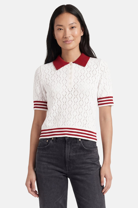 Pull multicolore de ONLY® avec motif ajouré, col et rayures rouges, manches courtes, porté avec un jean foncé.