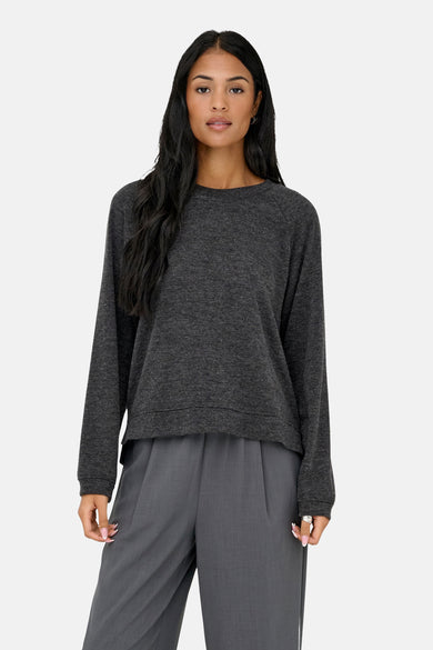 Grijze rondehals trui van ONLY, gedragen met een grijze broek met hoge taille en zwarte schoenen.