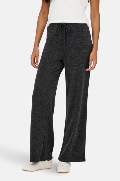 Grijze joggingbroek van ONLY, met trekkoord, gedragen met een wit T-shirt en witte sportschoenen.