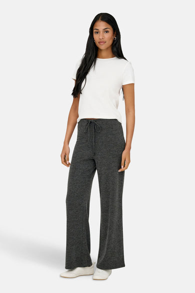 Jogging gris de ONLY, avec cordon de serrage, porté avec un t-shirt blanc et des chaussures de sport blanches.
