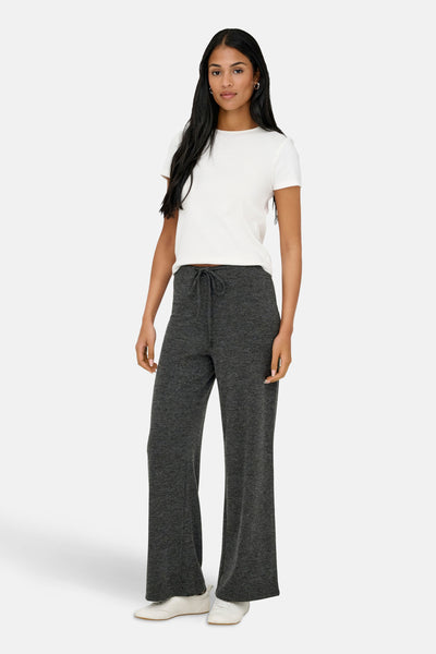 Jogging gris de ONLY, avec cordon de serrage, porté avec un t-shirt blanc et des chaussures de sport blanches.
