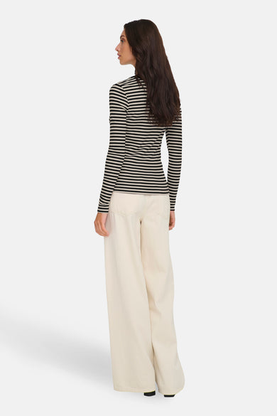 T-shirt à manches longues noir et blanc rayé de ONLY®, porté avec un pantalon ample écru.